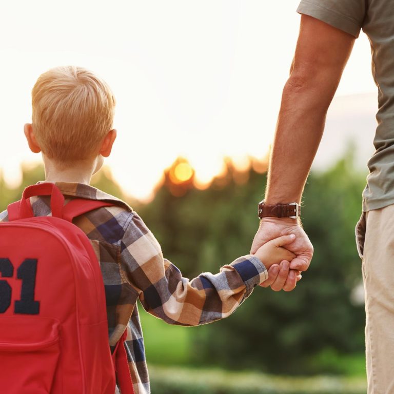 enfant tenant la main de son père rentrée scolaire