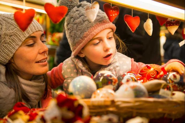 Maman et fille qui regardent les boules de noel sur un marché de noel