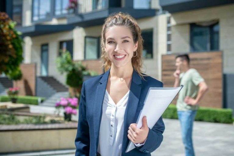 femme agent immobilier devant une maison