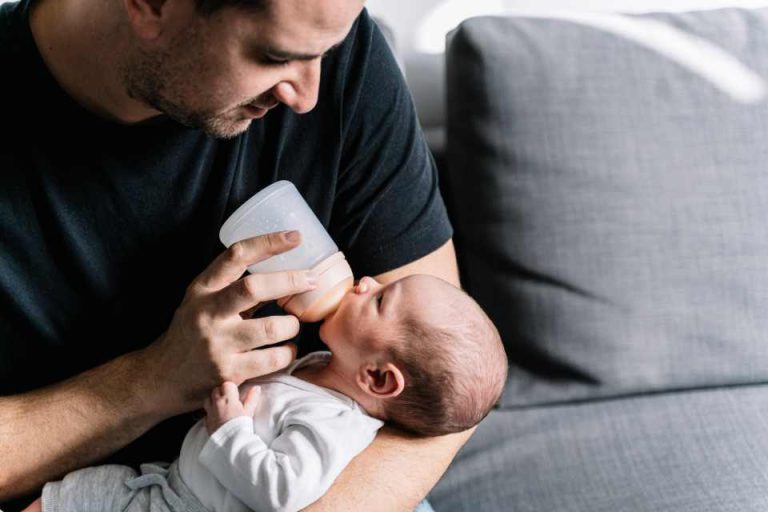 Père qui donne le biberon à son nouveau né