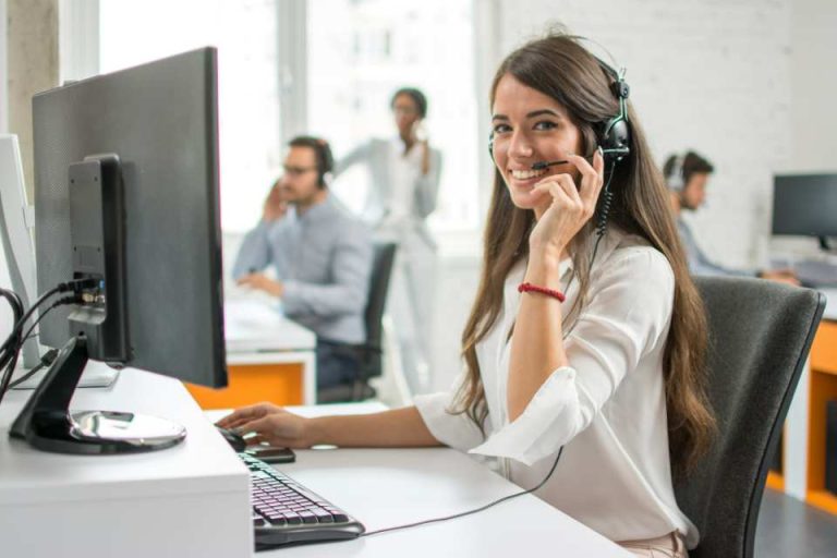Femme à son bureau , au téléphone avec un casque