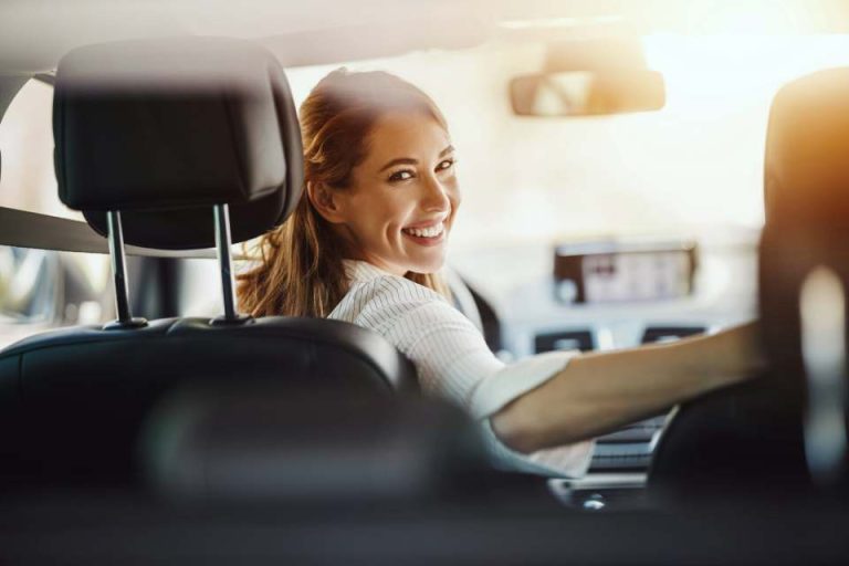 conductrice dans sa voiture qui regarde à l'arrière