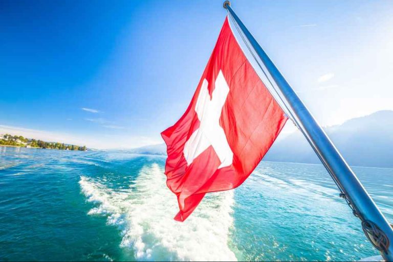 drapeau suisse d'un bateau avec en fond le lac léman