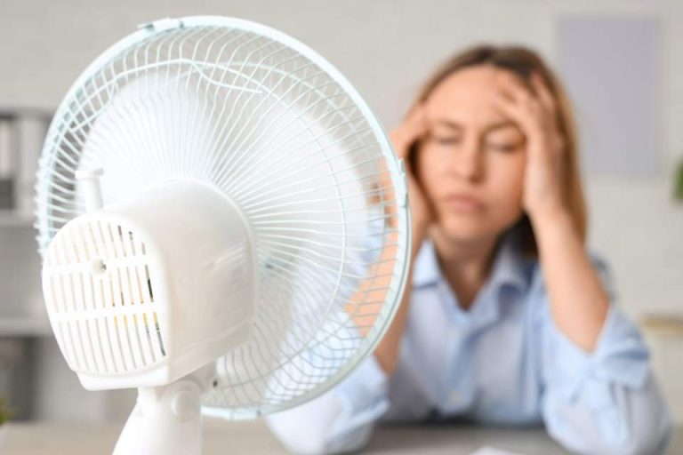 femme souffrant de la chaleur devant un ventilateur