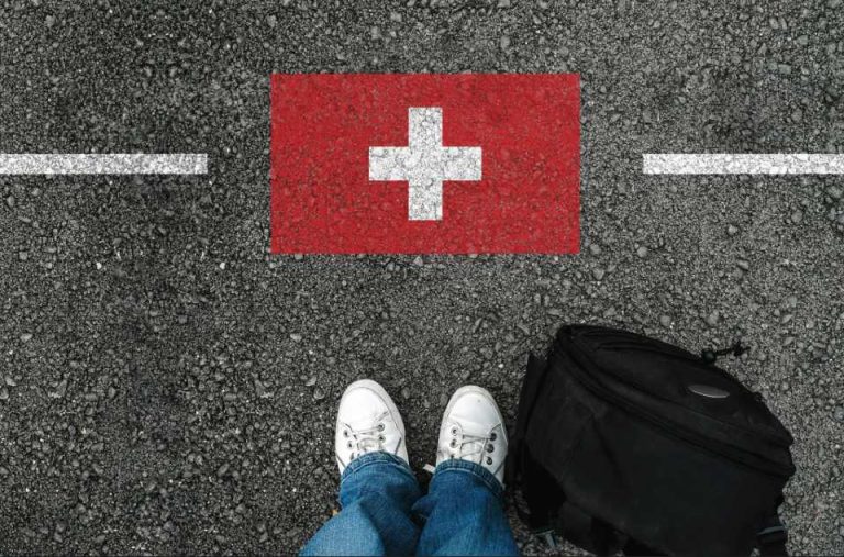 jambes vue d'en haut devant un drapeau suisse dessiné au sol