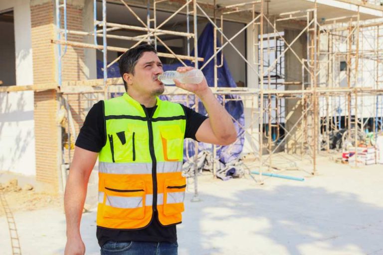 employé de chantier boit de l'eau sur un chantier